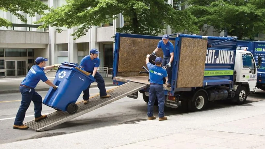 Professional trash removal team loading garbage bins into a cleanup truck