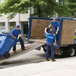 Professional trash removal team loading garbage bins into a cleanup truck