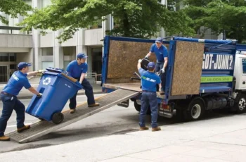 Professional trash removal team loading garbage bins into a cleanup truck